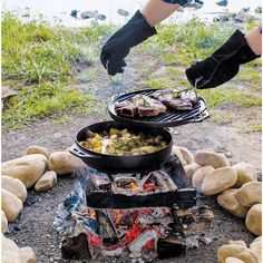 a person cooking food over an open fire