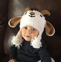 a baby wearing a crocheted sheep hat