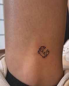 a small tattoo on the side of a woman's stomach