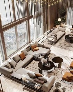 a living room filled with lots of couches and tables in front of large windows