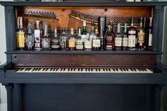 an old piano with liquor bottles on it