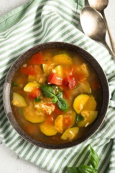 a bowl of vegetable soup on top of a green and white towel