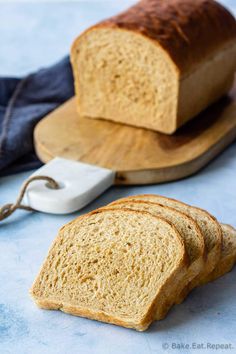 two slices of bread sitting on top of a cutting board next to a loaf of bread