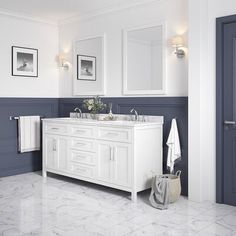 a white bathroom with two sinks and mirrors on the wall next to blue doored doorway