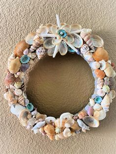 a wreath made out of seashells hanging on the wall