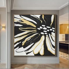 a large painting hanging on the wall in a room with hardwood floors and white walls