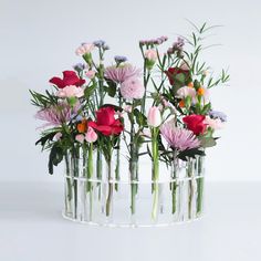 a vase filled with lots of flowers on top of a table