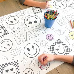 two children drawing on a large sheet of paper