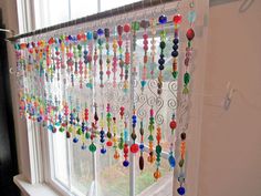 colorful beads hanging from the side of a window