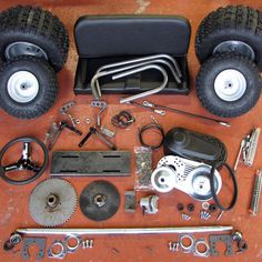 an assortment of tools and spares laid out on a table with wheels, wrenches, screwdrivers and other items