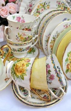 a table topped with plates and cups covered in floral designs on top of each other