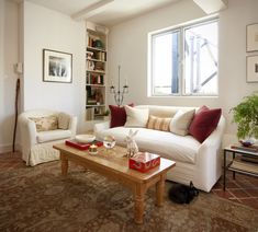 a living room filled with furniture and a cat laying on the floor next to it