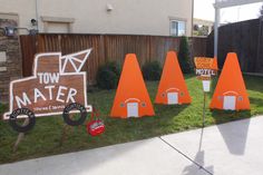 several orange traffic cones sitting in the grass near a sign that says tow water and there is a motel