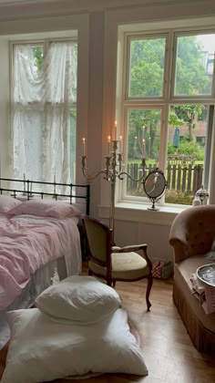 a bed room with a neatly made bed next to two windows and a chair in front of it