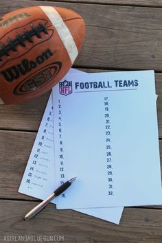 a football sitting on top of a wooden table next to a pen and paper calendar