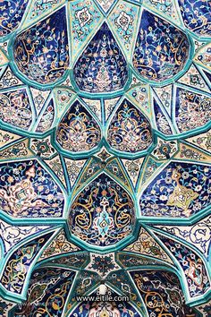 an intricately decorated wall with blue and green tiles