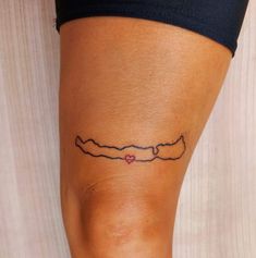 a woman's leg with a small tattoo on the lower part of her thigh