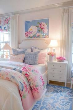 a bedroom with pink and blue flowers on the bed