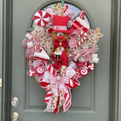 a christmas wreath with candy canes, candies and gingerbreads on the front door