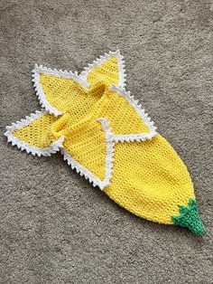 a knitted banana laying on the ground