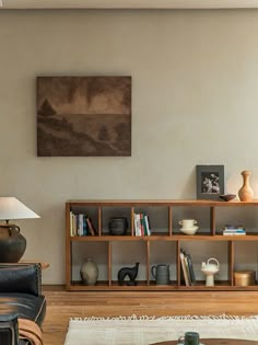 a living room filled with furniture and a painting on the wall above it's bookshelf