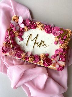 a cake with pink flowers and the letter m on it