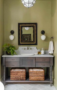 a bathroom vanity with two baskets under the sink and a mirror above it on the wall