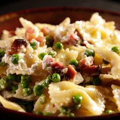 a bowl filled with pasta and peas on top of a table