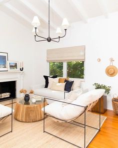 a living room with white furniture and wood flooring in front of a fire place