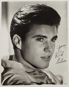 an old black and white photo of a man with short hair wearing a collared shirt