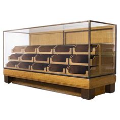 a wooden and glass display case filled with lots of brown drawers on top of a white background