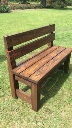 a wooden bench sitting on top of a lush green field