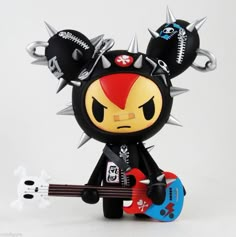 a toy with spikes on its head holding a guitar