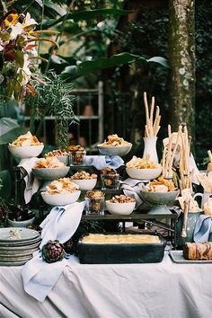 a buffet table with many plates and bowls on it