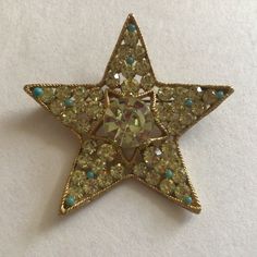 BSK signed star figural brooch encrusted with free chatons and faux turquoise cabochons in a high quality gold tone setting. Measurements: 2 14 x 2 14 In pristine condition. All chatons are present and brilliant. All faux turquoise cabochons are present with no damage whatsoever. No flaking or discoloration to the gold tone. Pin closure in perfect working condition. Star Brooch, Smoky Topaz, Vintage Star, S K, Chic Design, Fig, Beautiful Necklaces, Brooch Pin, Brooches