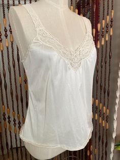 Sweet little cream colored camisole with stretchy lace straps. Brand is vanity fair, tag  says size 36/42, the dress form is an 8 and it is loose on it. Modern size large, or 10. it has some stretch. Lace V-neck Camisole, Feminine Summer Camisole With Lace Bodice, Fitted Sheer Lace Camisole Top, Delicate Fitted Camisole With Spaghetti Straps, Fitted Delicate Spaghetti Strap Camisole, Feminine Delicate Lace Camisole Top, Delicate Lace Cami Top, Delicate Fitted Camisole For Summer, Coquette Lace Camisole