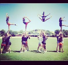 a group of people standing on top of each other in the air with their hands up