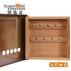 an open wooden box with hooks in it and chinese writing on the bottom right hand corner