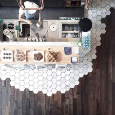 an overhead view of a kitchen with wooden flooring and white hexagonal tiles