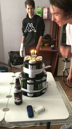 a man standing next to a table with a cake on it