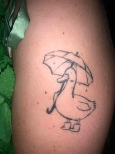 a tattoo on the leg of a man with an umbrella and ducky holding a cane