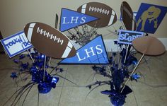 football themed centerpieces are arranged on the floor in front of a wall with blue and brown decorations