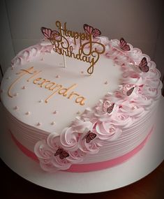 a birthday cake decorated with pink flowers and butterflies