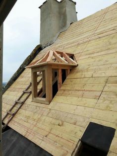 an unfinished roof with a small window in the center