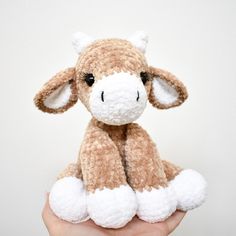 a hand holding a small stuffed animal in it's left hand, with one eye open