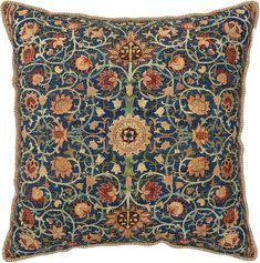 a blue and red pillow with an intricate design on the front, in gold trimmings