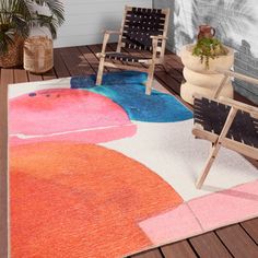 a colorful area rug with two chairs on it