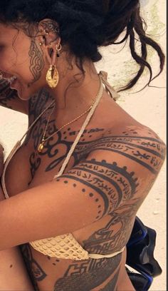 a woman with tattoos on her body holding a cell phone