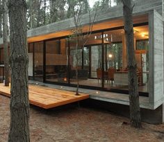 a modern house in the woods surrounded by trees