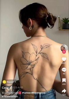 the back of a woman's body with tattoos on her upper and lower back